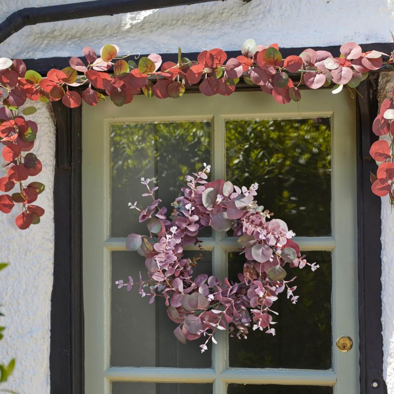 Faux Eucalyptus garland and wreath decorating a door