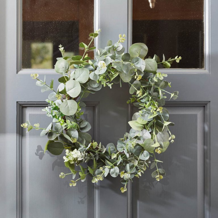 A faux Eucalyptus wreath placed on a front door